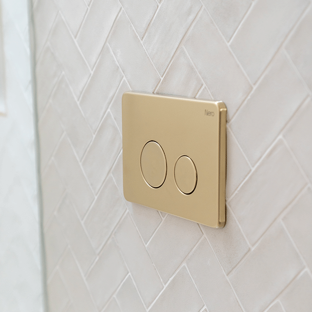 Nero brushed brass toilet flush plate button on white subway tiles | Cam and Jules ensuite bathroom | The Blue Space